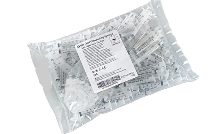 A clear plastic bag containing multiple small clear plastic syringes with white labels, shown on a light gray background. A white product label is visible on the front of the bag.